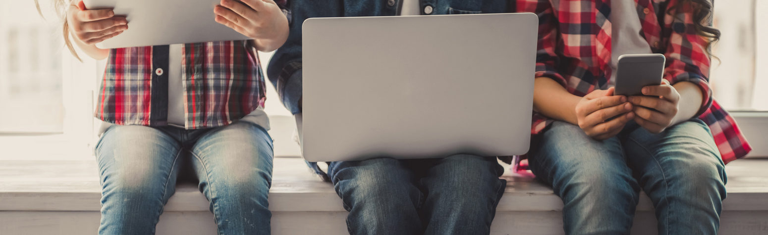 Young people on a computer, tablet and cell phone