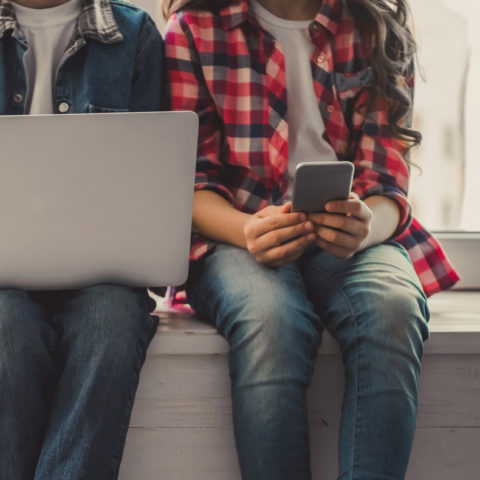 Young people on a computer, tablet and cell phone