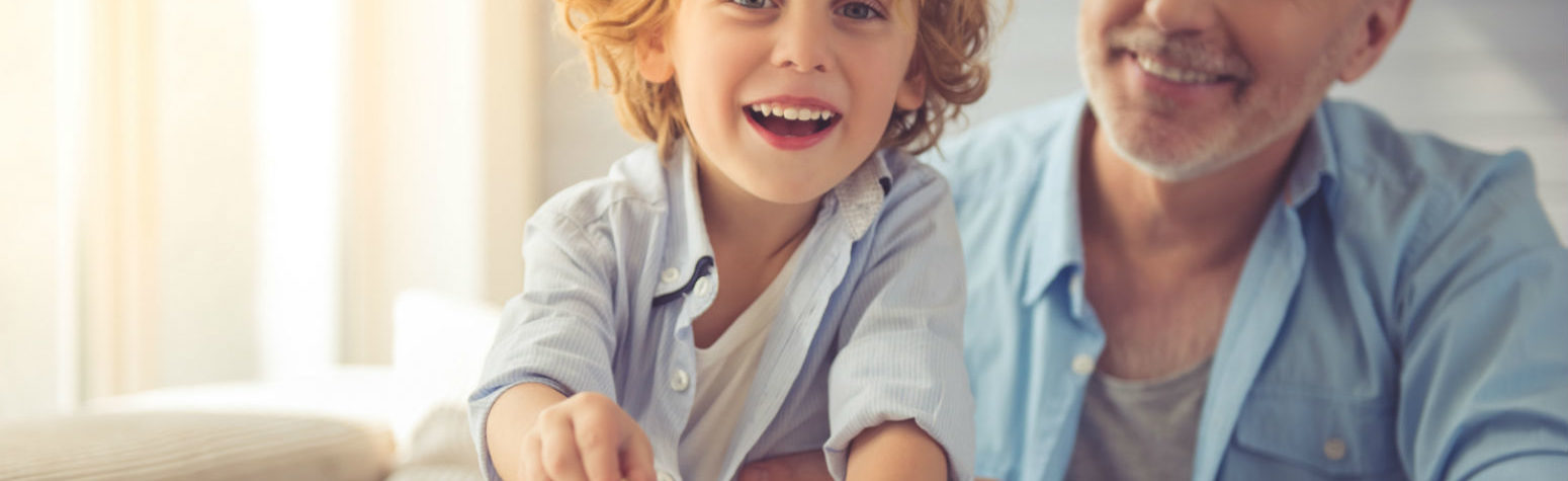 smiling boy putting money in piggybank