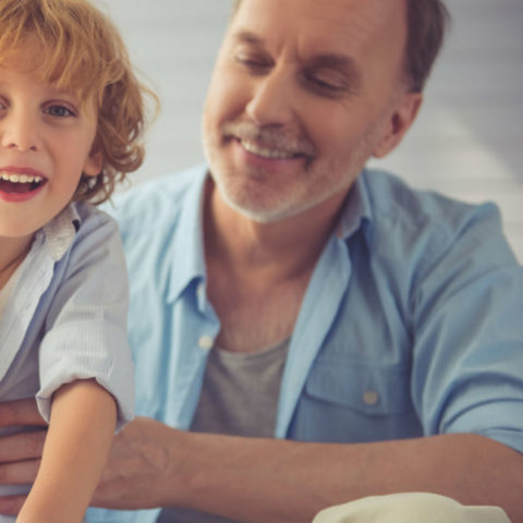 smiling boy putting money in piggybank