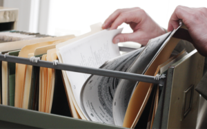 Documents on a folder, hand sifting through the documents