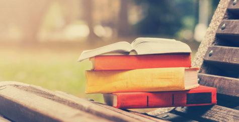 Books sitting on a park bench