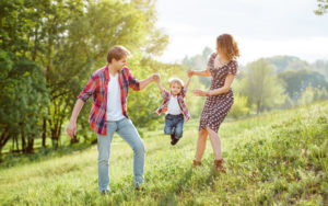 Father and mother walking with their son on a sunny afternoon.