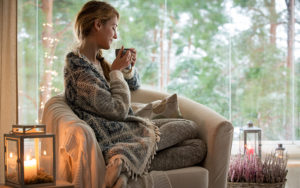 Young woman sitting home by the window