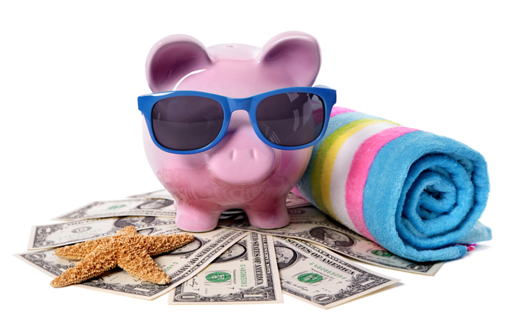 Piggy bank wearing blue sunglasses, standing on top of cash with a beach towel and star fish.