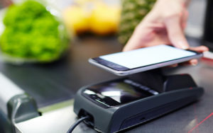 A woman uses her phone to pay for her groceries