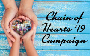 Hands holding a heart with pictures of children inside. Logo says Chain of Hearts 2019 Campaign