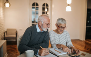 Man and woman in their 60s look over finances.