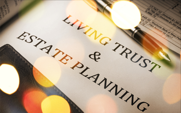 The words "living trust" and "estate planning" are shown on a piece of paper with a pen.