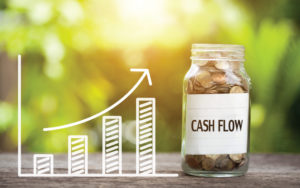 Graph against nature scene leading to jar of change that says "Cash Flow."