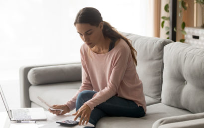 Woman sitting at couch budgeting