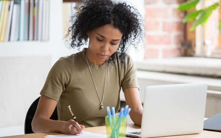 Young Lady filling out w-4 tax form at her desk