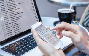 Person checking mail via phone and computer