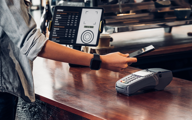 Man paying for coffee with mobile wallet