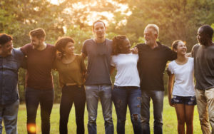 Group of individuals standing outside looking happy.