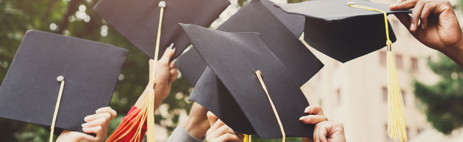 Graduation mortar boards being thrown in air