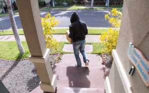 Doorbell camera shows someone stealing package from porch.