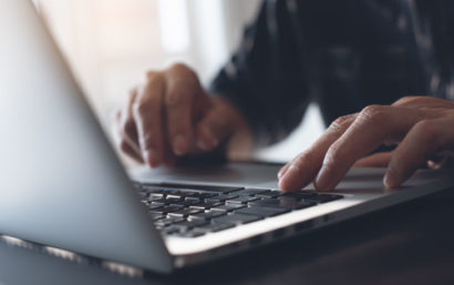 Close-up of man typing at computer