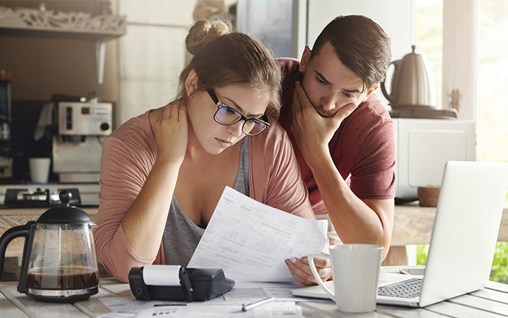 Man and woman look over financials while looking worried.